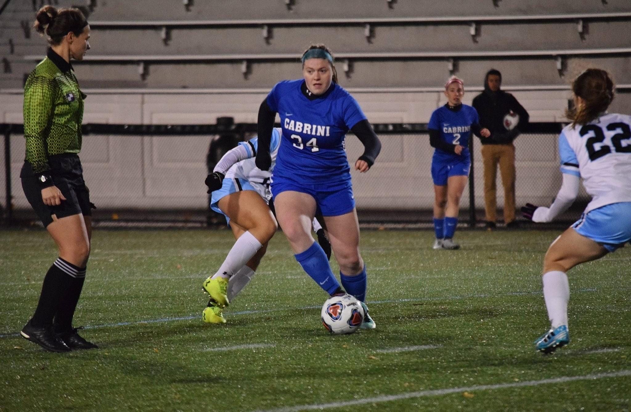 Kane dribbling a ball around a defender. Photo by Cabrini Athletics. 