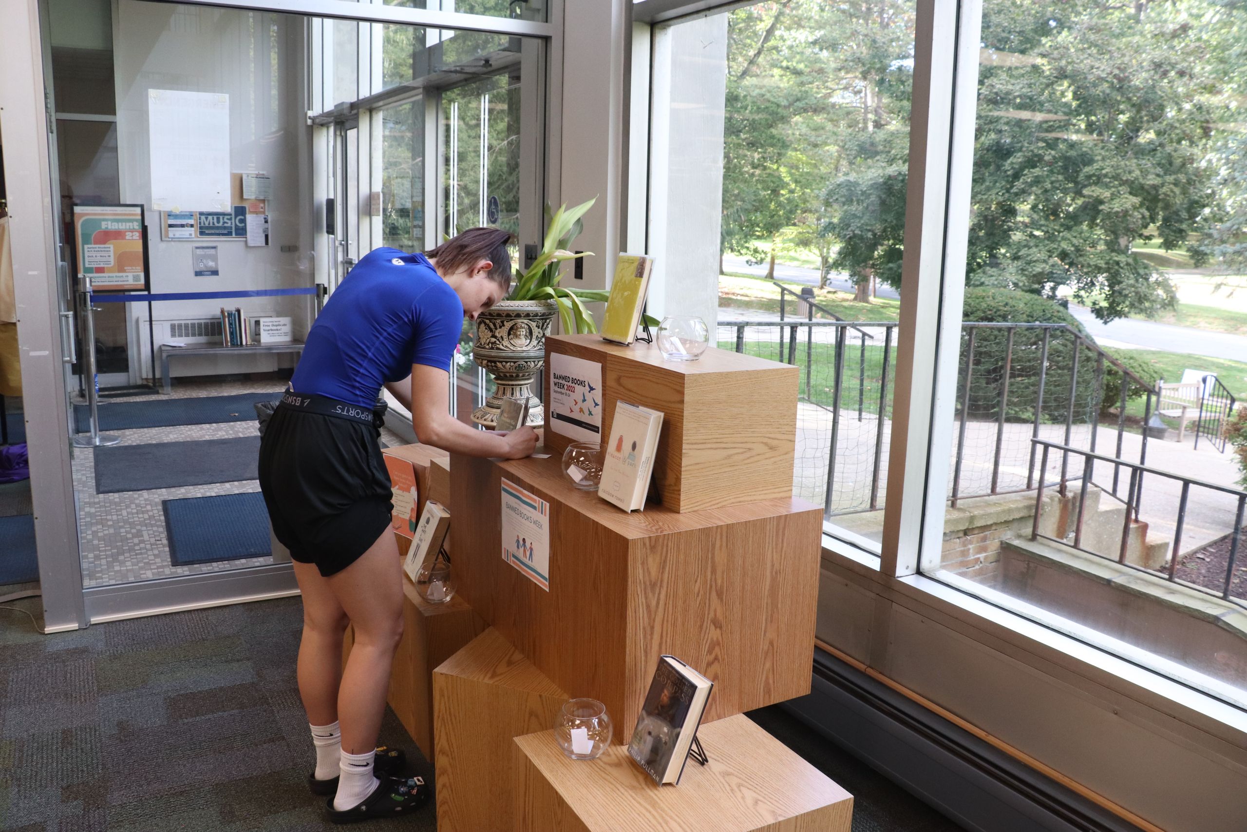 Miranda Liebtag, senior psychology major, at the library's Banned Books display, guesses why each book is banned. Photo by Ryan Byars.