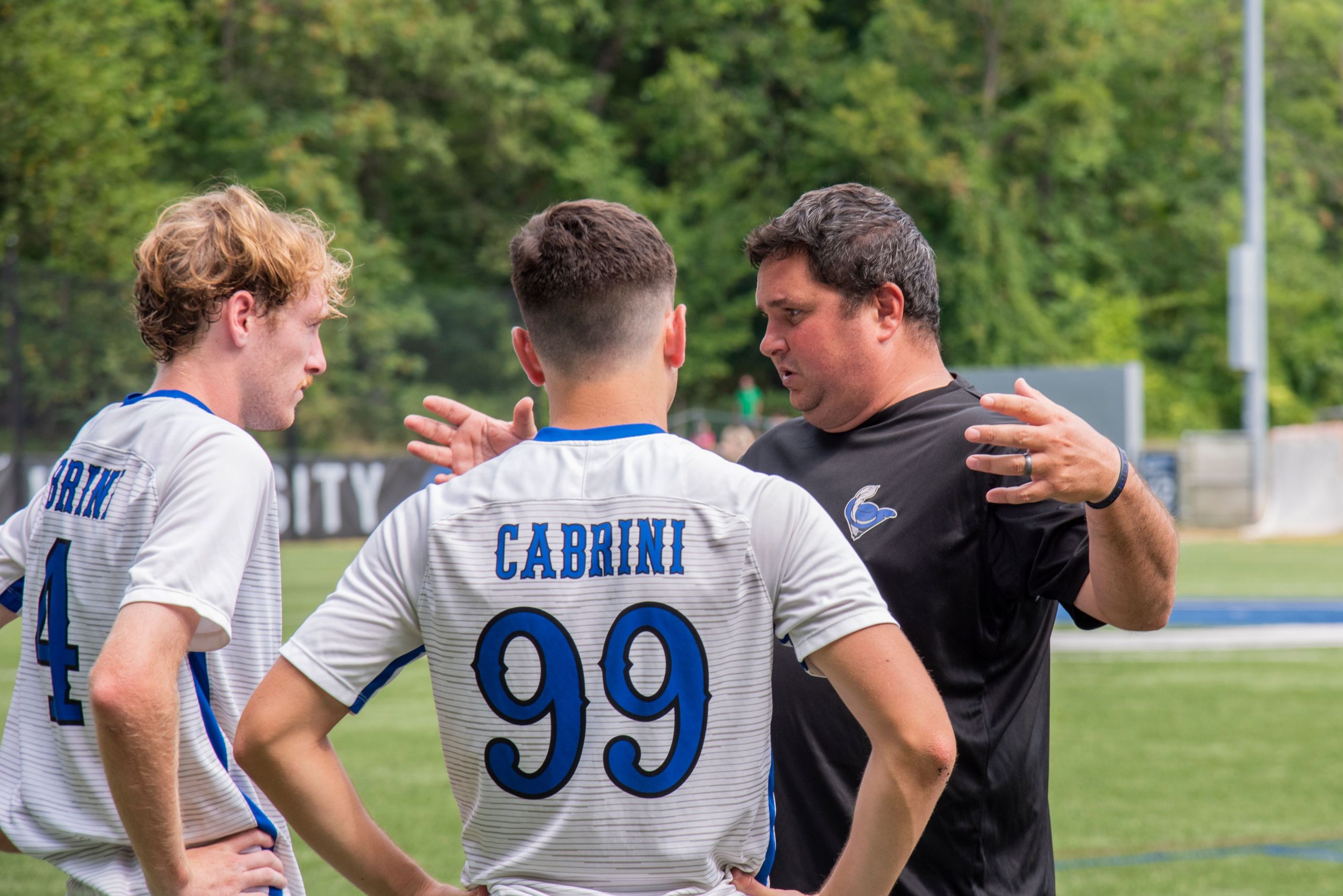 Head Coach of Cabrini men's soccer, Rob Dallas, and his players before the game. Photo by Linda Johnson.