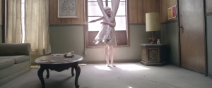 Creative Commons Dancer Maddie Ziegler clings to the curtains in Sia’s “Chandelier” video. 