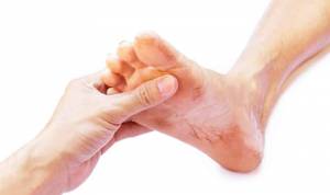 A hand holding a dirty foot