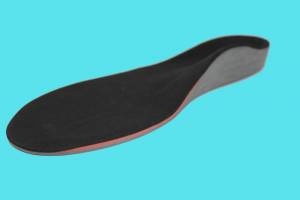 A custom foot orthotic on a teal background