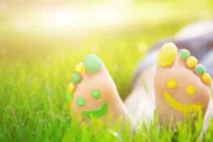 A pair of children's feet painted smiley faces on