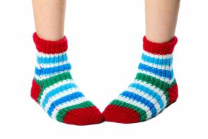 A pair of feet wearing brightly covered socks standing intoed