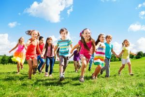A large group of kids running in the park