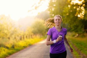 A lady goin for a run early in the morning listening to her headphones