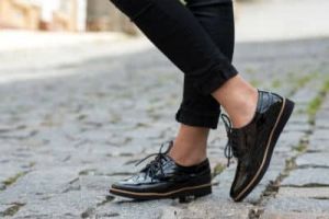 A pair of stylish black shoes on a lady