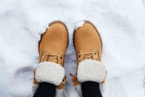 A person wearing a pair of boots in the snow