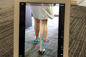 An iPad showing an analysis of a lady walking, with biometric lines drawn.