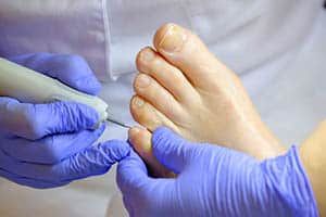 A podiatrist treats the feet of a patient