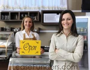 Happy owner of a cafe showing open sign