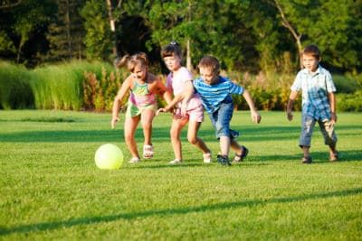 Four Children playing soccer in the park