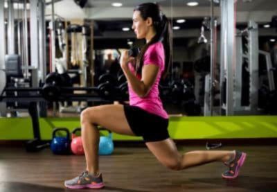 A woman working in a gym doing a lunge