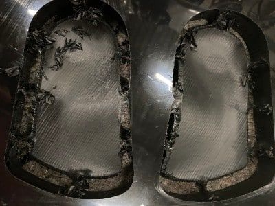 A pair of orthotics on a block after being cut