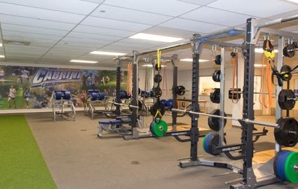 Many weights and exercise machines fill the room.