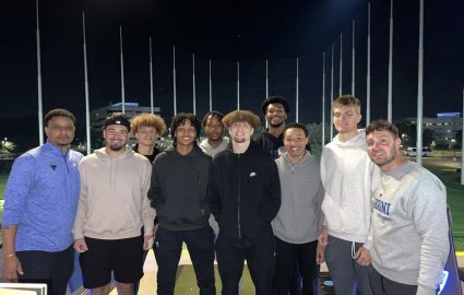 Current Cabrini men's basketball players with assistant coach Kevin Murray (far left) and new head coach Ryan Van Zelst (far right) at Top Golf in King of Prussia. All are smiling and enjoying their final year together.