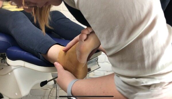 Podiatrist Laura strapping a foot