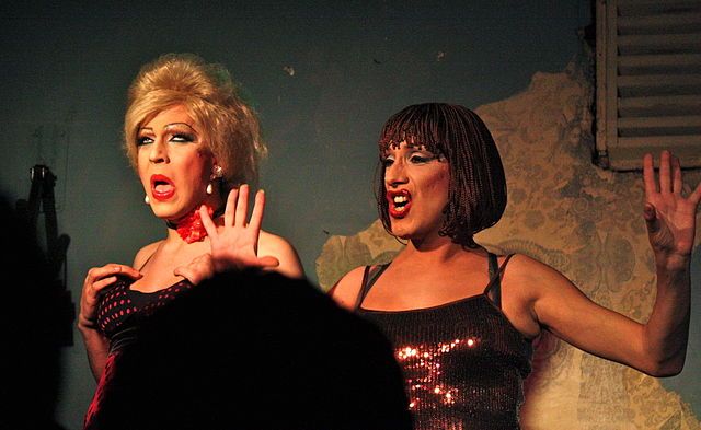 Two drag queens perform during a show in London. Photo by Kyle Taylor via Wikimedia Commons