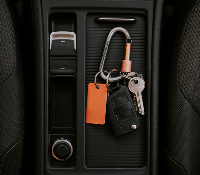 High Cost of Replacing a Car Key | CMA Toyota of Martinsburg | Car Keys laying on top of black leather center console of a car 