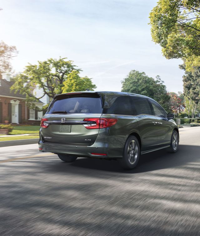 New 2025 Honda Odyssey at Delaney Honda | Rear profile of a 2025 Honda Odyssey driving down a neighborhood