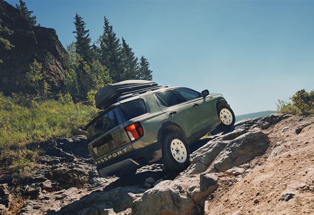 New 2026 Honda Passport at Delaney Honda | Green 2026 Honda Passport driving up a rocky hill