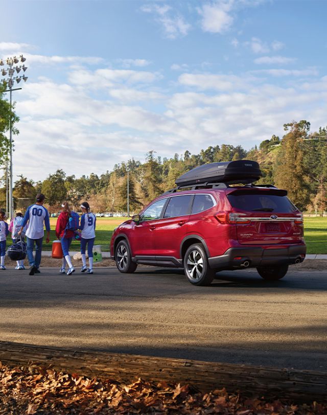 2025 Subaru Ascent at Delaney Subaru in Indiana, PA | Rear profile of a red 2025 Subaru Ascent parked while kids sports team are walking away