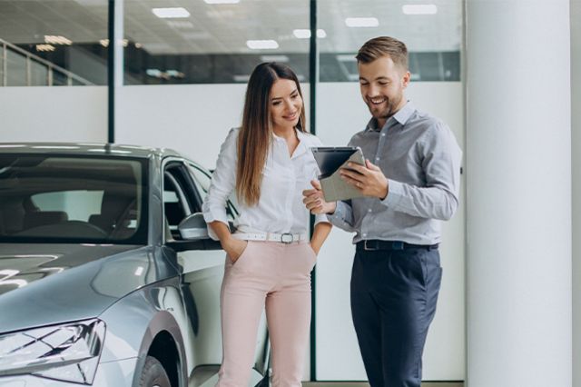 When to Trade In Your Car | Delaney Toyota of DuBois in DuBois, PA | Sales associate reviewing paper work with customer inside of dealership
