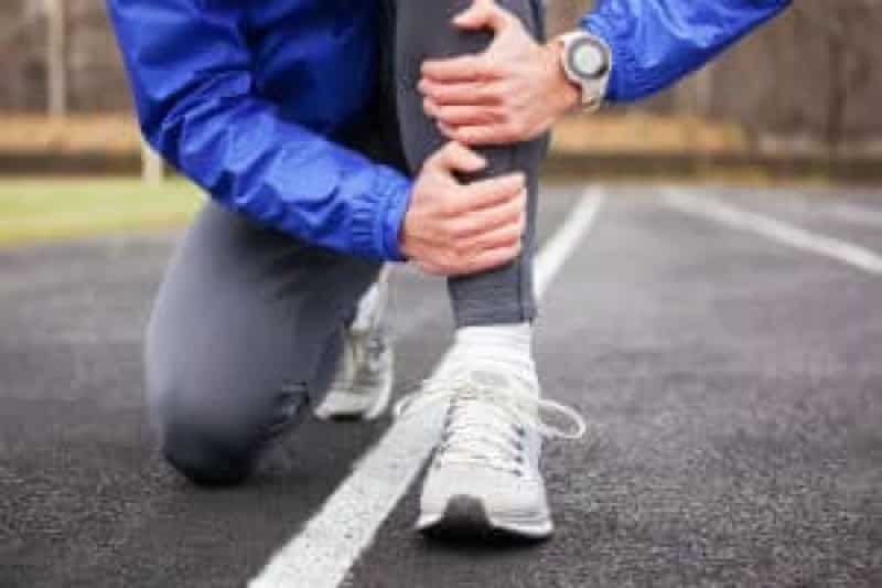 A man holds his leg in pain