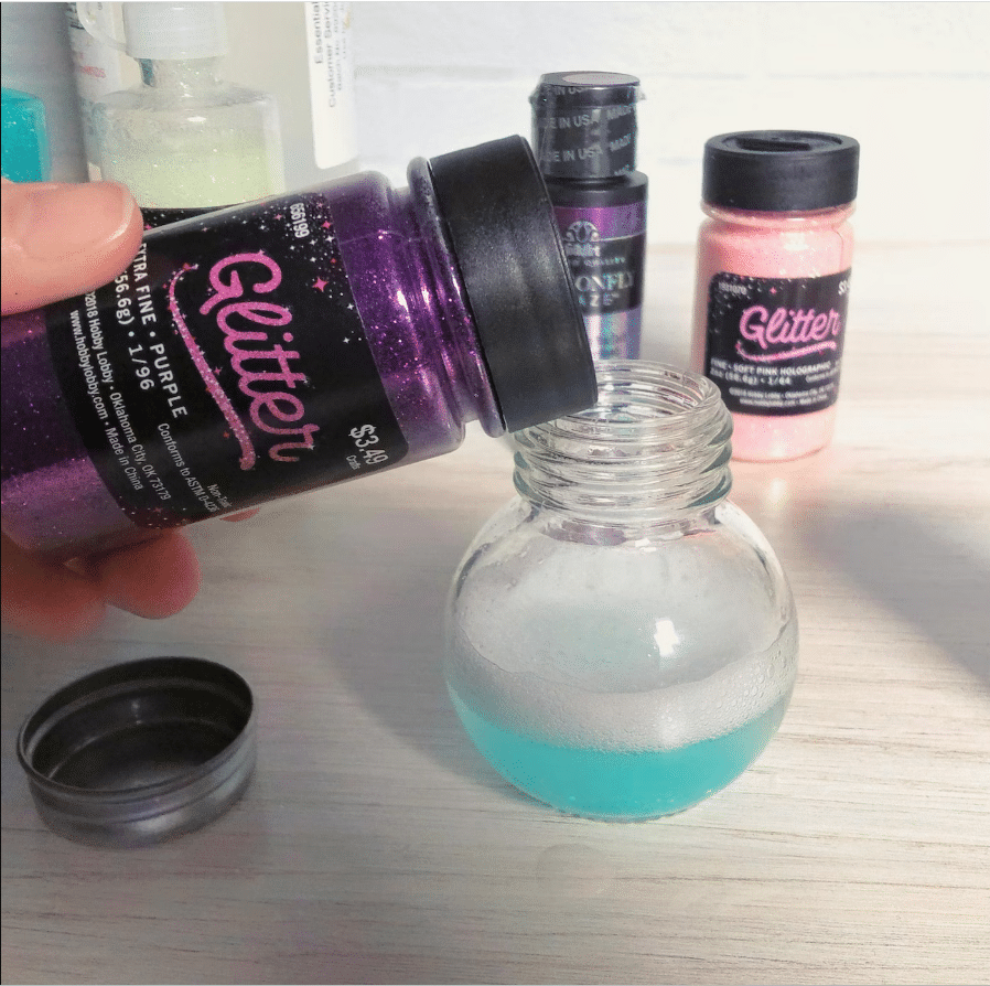 adding purple glitter to mixture in jar