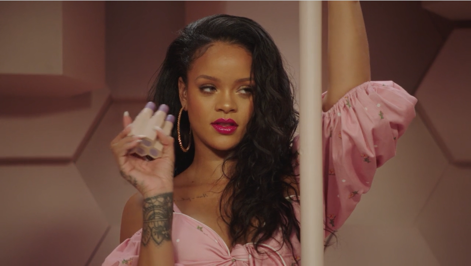 Rihanna poses with Fenty Beauty products.